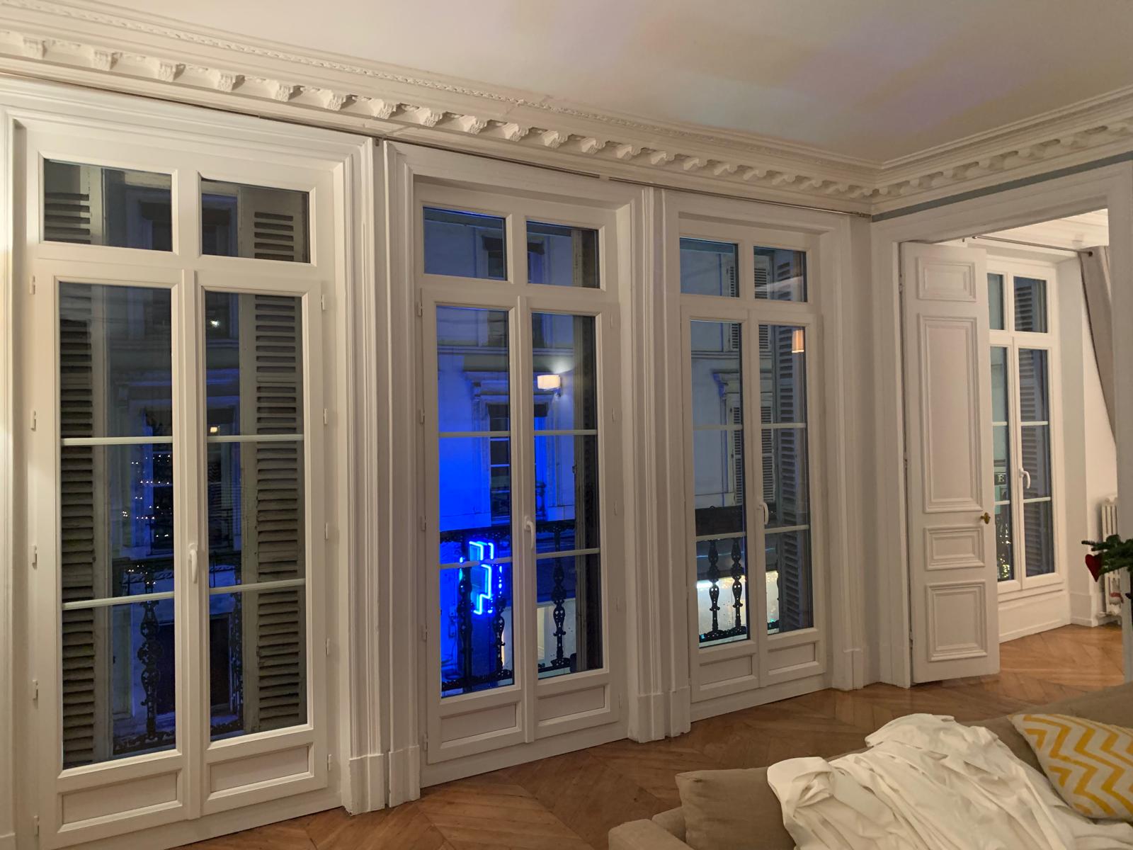 Trois portes-fenêtres blanches installées en façade.